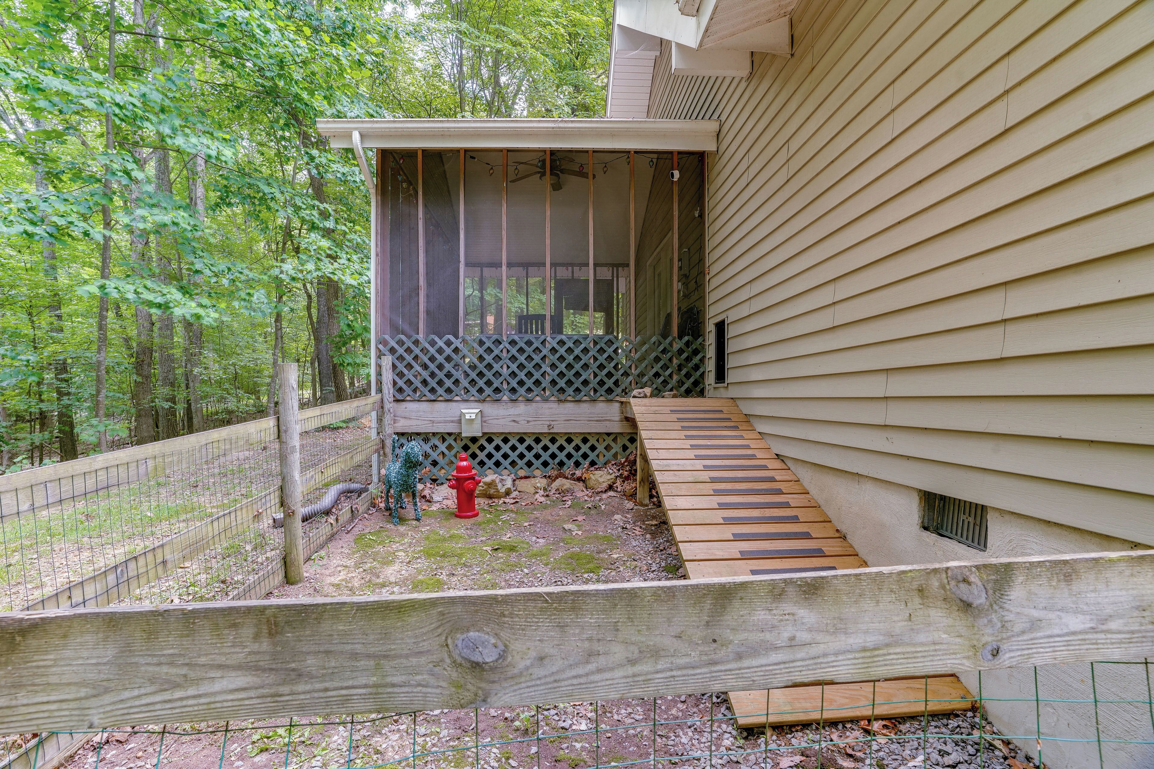 A wooden deck with a wooden ramp leading to a covered porch.