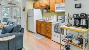 A compact kitchen with wooden cabinets, a white refrigerator, a microwave, and a coffee station. - Cabin w/ Deck & Screened-in Porch in New Market! (New Market)
