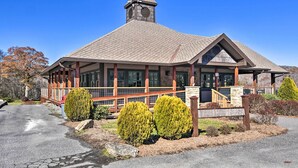 A lodge with a prominent tower, large windows, and a covered porch. - Steps to Ski Resort: Sugar Mountain Condo! (Banner Elk)