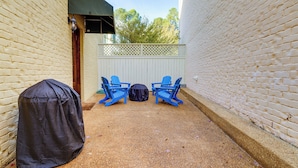 A covered patio area with two blue chairs and a barbecue grill. - Hector's Hotty Toddy: 2 Mi to Ole Miss (Oxford)