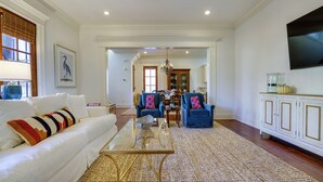 A spacious living room with a white sofa, a glass coffee table, and blue armchairs. - Hector's Hotty Toddy: 2 Mi to Ole Miss (Oxford)