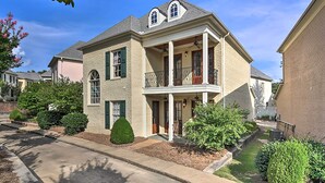 A two-story house with a balcony, a front porch, and a small front yard with landscaping. - Hector's Hotty Toddy: 2 Mi to Ole Miss (Oxford)