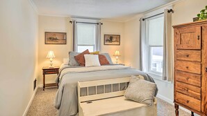 A bedroom with a bed, two bedside lamps, a dresser, and two windows with curtains. - Penn Yan House Rental - Close to Wineries! (Penn Yan)