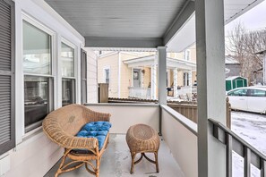 A covered porch with wicker furniture, a view of neighboring houses, and a parked car. - Penn Yan House Rental - Close to Wineries! (Penn Yan)