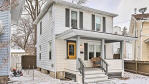 A two-story house with a front porch, a yellow door, and a satellite dish. - Penn Yan House Rental - Close to Wineries! (Penn Yan)