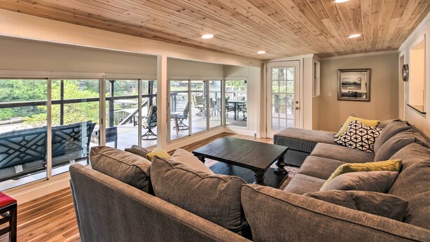 A spacious living area with a wooden ceiling, large windows, and a comfortable seating arrangement. - Dock, Deck & Boat Slip: Lakefront Eucha Home (Eucha)