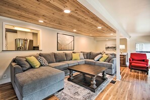 Relax in this stylish living room with a large sectional sofa, coffee table, and armchair.