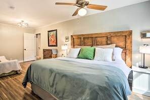 Cozy retreat with a large bed, ceiling fan, and bedside table.