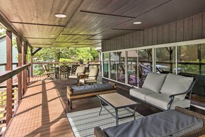 Relax in this serene outdoor seating area with a sofa, chairs, and table, surrounded by lush greenery and natural light.
