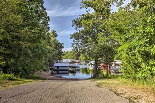 Une propriété au bord du lac, avec une all ée pavée menant à un quai.