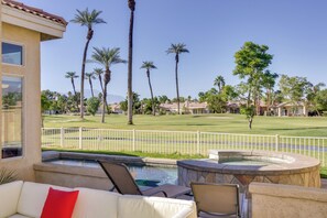 A pool area with lounge chairs, a hot tub, and a view of a golf course with palm trees. - Country Club Home w/ Pool & Spa, 2 Mi to Coachella (Indio)