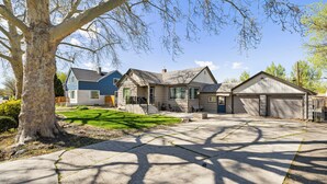 A residential property with a driveway, a large tree, and two houses with attached garages. - Spacious Family Home w/ Garage Game Room & Office! (Boise)