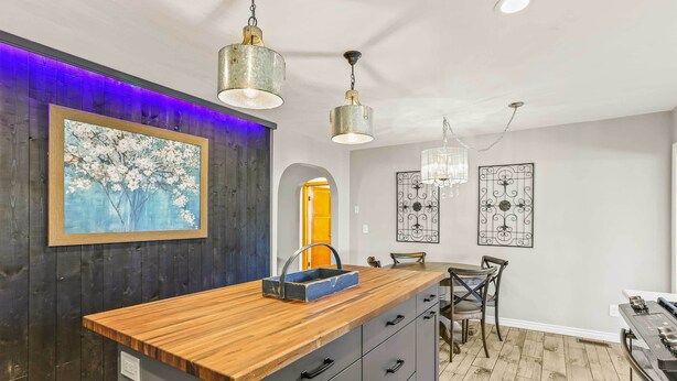 A modern kitchen with a wooden countertop, black cabinets, and pendant lighting. - Spacious Family Home w/ Garage Game Room & Office! (Boise)
