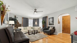 A modern living room with a sofa, armchair, coffee table, and a ceiling fan. - Spacious Family Home w/ Garage Game Room & Office! (Boise)