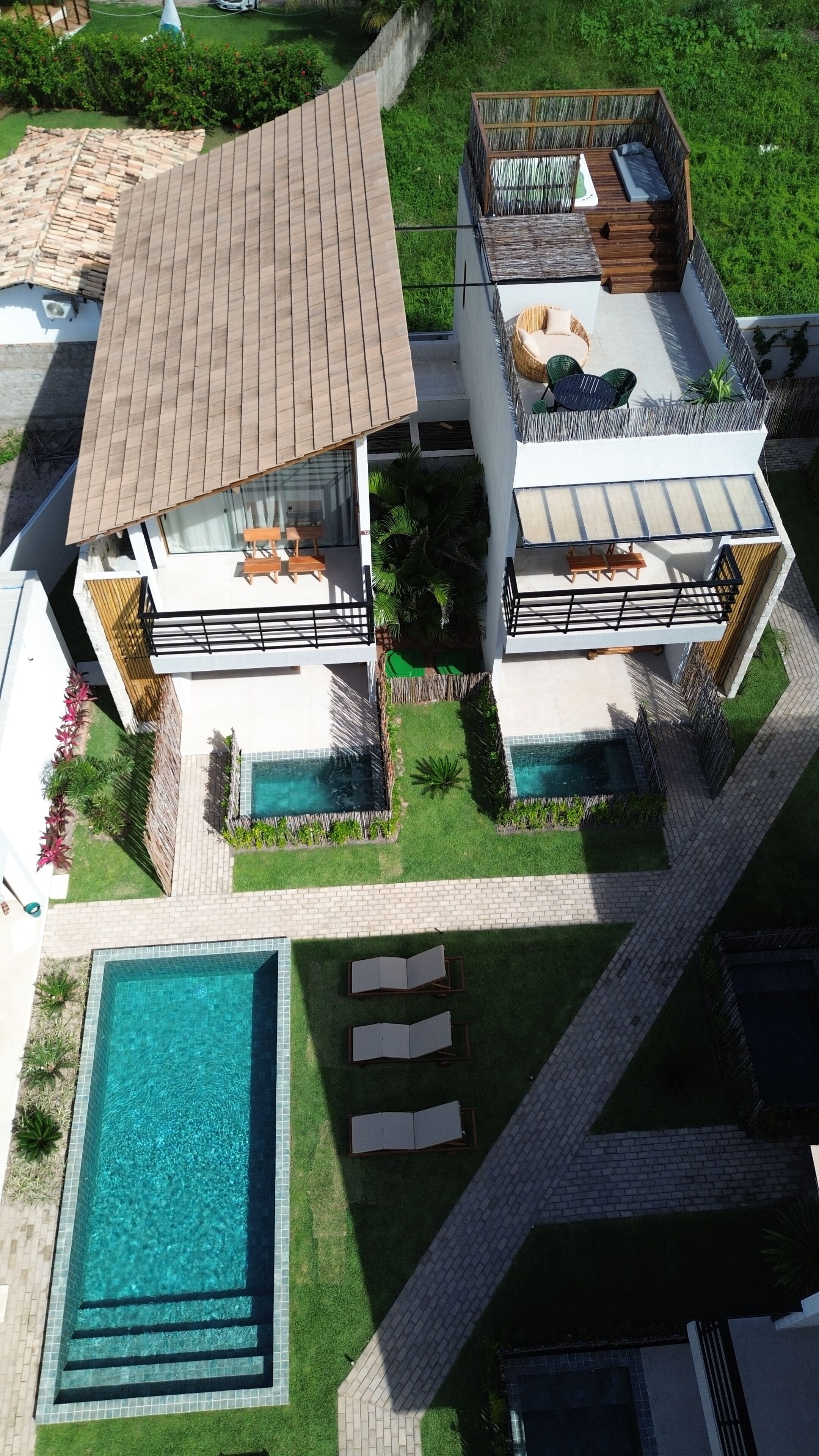 A modern two-story house with a swimming pool, outdoor seating, and a well-maintained garden.