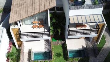 A modern two-story house with a swimming pool, outdoor seating, and a well-maintained garden.