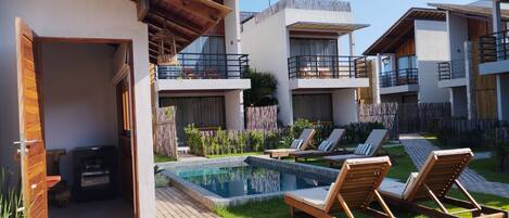 Ein modernes Resort mit Schwimmbad, Liegestühlen und einem gepflegten Garten.
