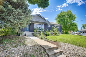 A residential house with a front yard, a driveway, and a small garden area. - Denver Vacation Home w/ Home Theater! (Denver)