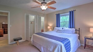 A bedroom with a bed, a ceiling fan, a window with curtains, and a bedside table with a lamp. - Hendersonville Home w/ Fire Pit: 5 Mi to Downtown! (Hendersonville)