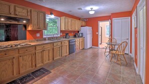A kitchen with wooden cabinets, a granite countertop, a built-in stove, and a refrigerator. - Hendersonville Home w/ Fire Pit: 5 Mi to Downtown! (Hendersonville)