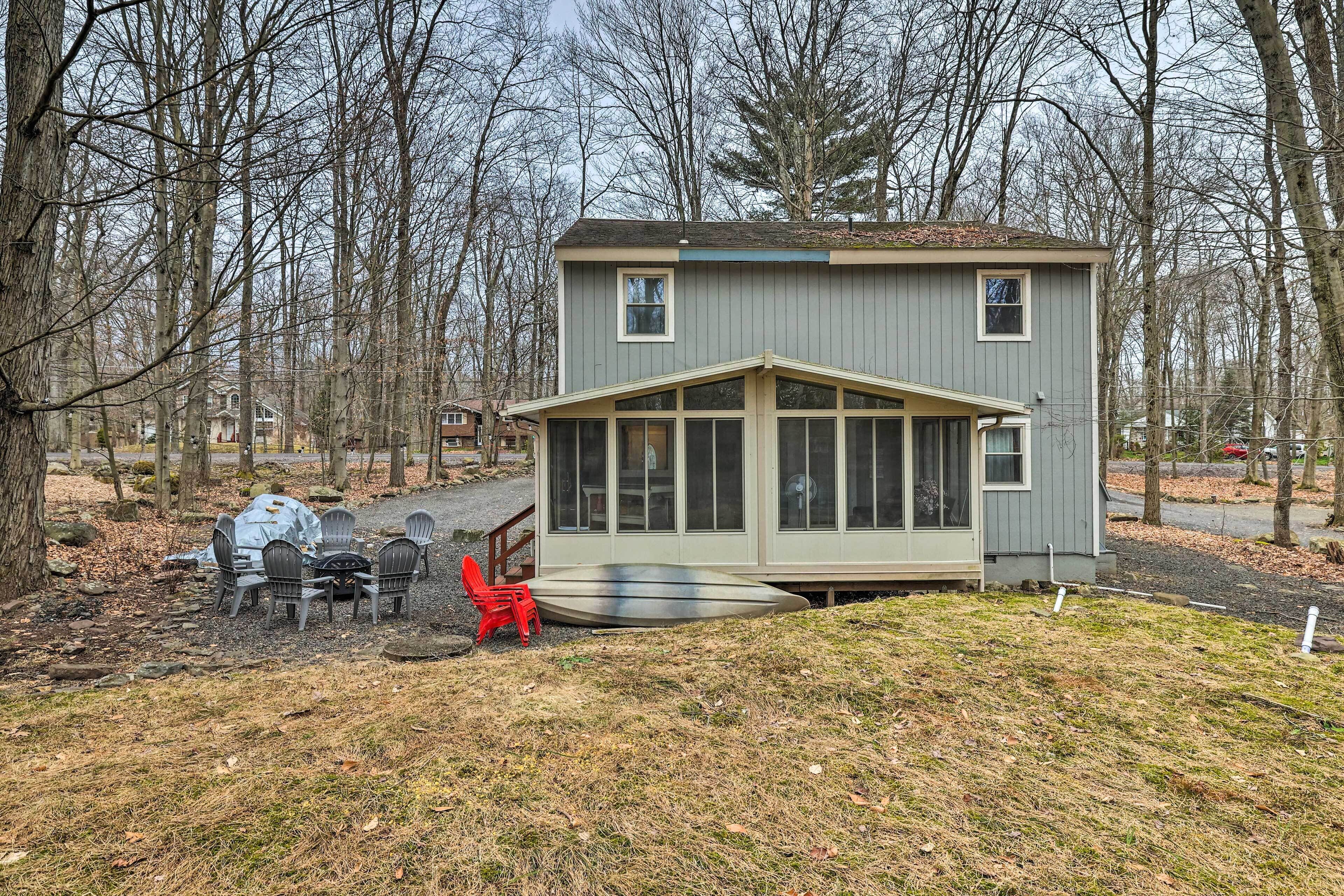 A small, single-story cabin with a porch and a covered outdoor seating area.