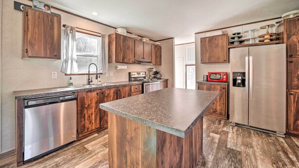 A modern kitchen with wooden cabinets, stainless steel appliances, and a granite countertop. - Asheville Area Home Near Blue Ridge Mountains (Leicester)