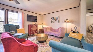A living room with a round coffee table, two sofas, a television, and a ceiling fan. - Asheville Area Home Near Blue Ridge Mountains (Leicester)