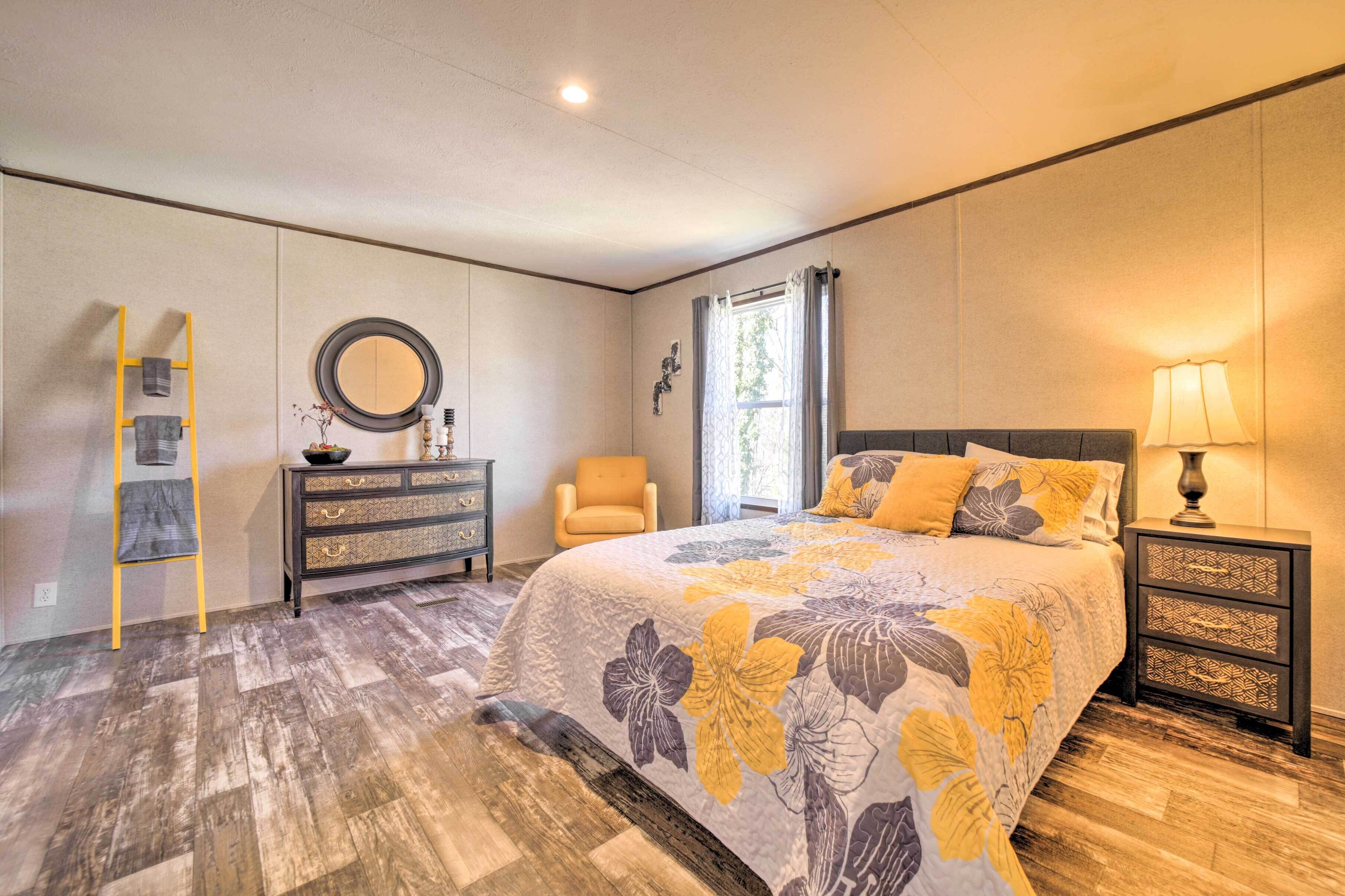 A bedroom with a bed, dresser, chair, and nightstand.