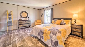 A bedroom with a bed, dresser, chair, and nightstand. - Asheville Area Home Near Blue Ridge Mountains (Leicester)