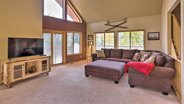 A spacious living room with a large sectional sofa, a flat-screen TV on a wooden console, and a ceiling fan. - Ski-in/ski-out Cabin: Lift to Brian Head Resort! (Brian Head)