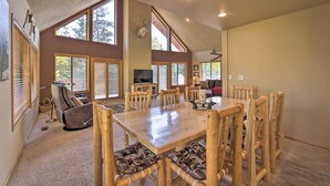 A spacious living room with a large wooden dining table, multiple chairs, a sofa, and a fireplace. - Ski-in/ski-out Cabin: Lift to Brian Head Resort! (Brian Head)