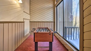 A foosball table in a room with wooden walls and large windows. - Brian Head Condo Near Lifts at Giant Steps! (Brian Head)