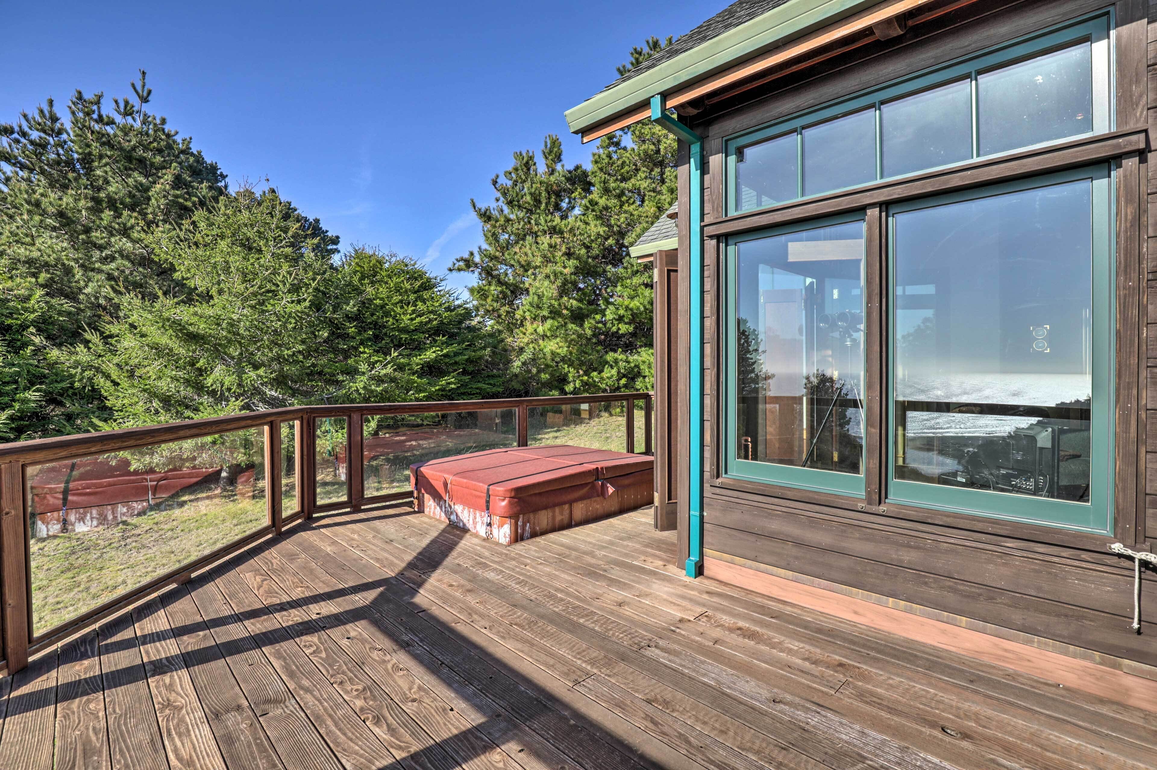 A wooden deck with a glass enclosure and a red bench.