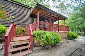 Une cabane en bois avec un porche et des marches rouges.