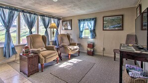 A living room with two armchairs, a small table, a lamp, and a bookshelf. - 2 Mi to Downtown Knoxville: Cozy Home w/ Patio (Knoxville)