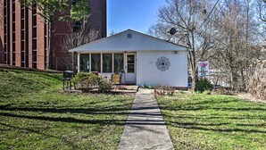 A small, single-story building with a sloped roof, a front door, and a small porch with a chair and table. - 2 Mi to Downtown Knoxville: Cozy Home w/ Patio (Knoxville)