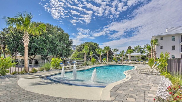 A swimming pool with a curved edge, surrounded by a paved deck and a fence. - 'salt & Serenity on 30a' Walk to Santa Rosa Beach! (Santa Rosa Beach)