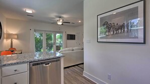A modern kitchen with granite countertops, stainless steel appliances, and a ceiling fan. - 'salt & Serenity on 30a' Walk to Santa Rosa Beach! (Santa Rosa Beach)