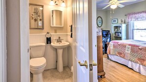 A bathroom with a toilet, sink, and mirror. - Nautical Lubec Cottage w/ Fire Pit & Grill! (Lubec)