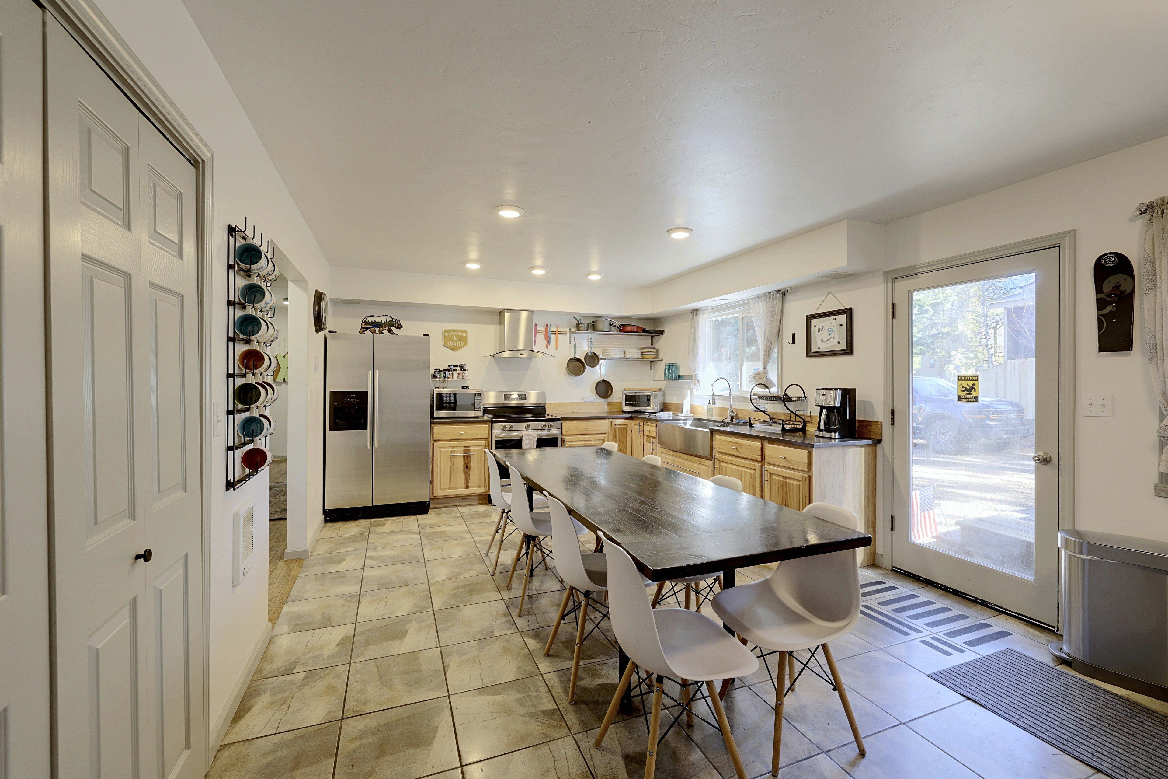 A modern kitchen with a central island, stainless steel appliances, and a view to the outside.