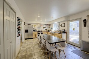 A modern kitchen with a central island, stainless steel appliances, and a view to the outside. - Updated Rustic Retreat Cabin: Walk to Payette Lake (McCall)