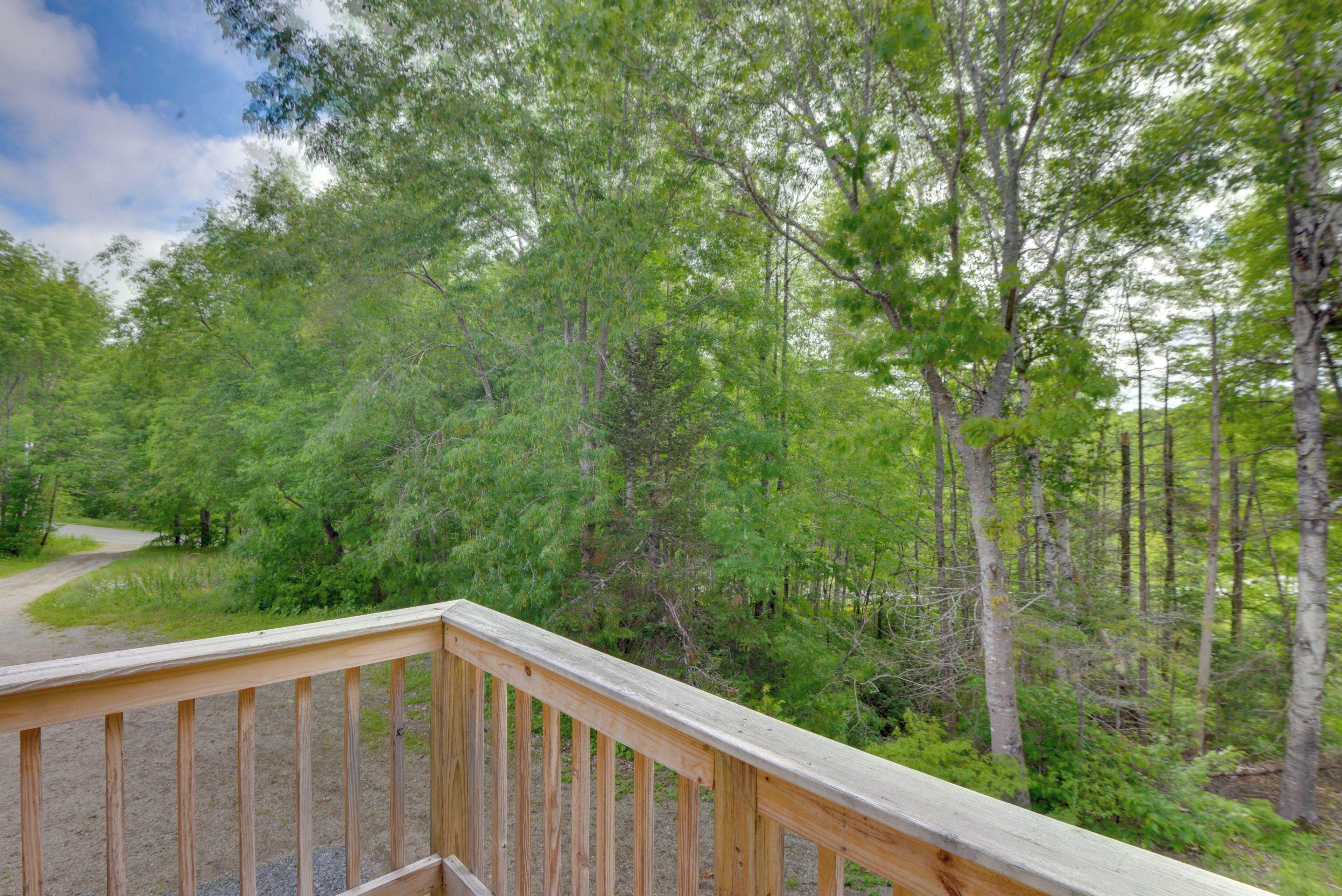 A wooden deck with a view of a forested area.