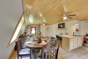 Comedor con techo de madera, una isla de cocina y una mesa para cuatro comensales.