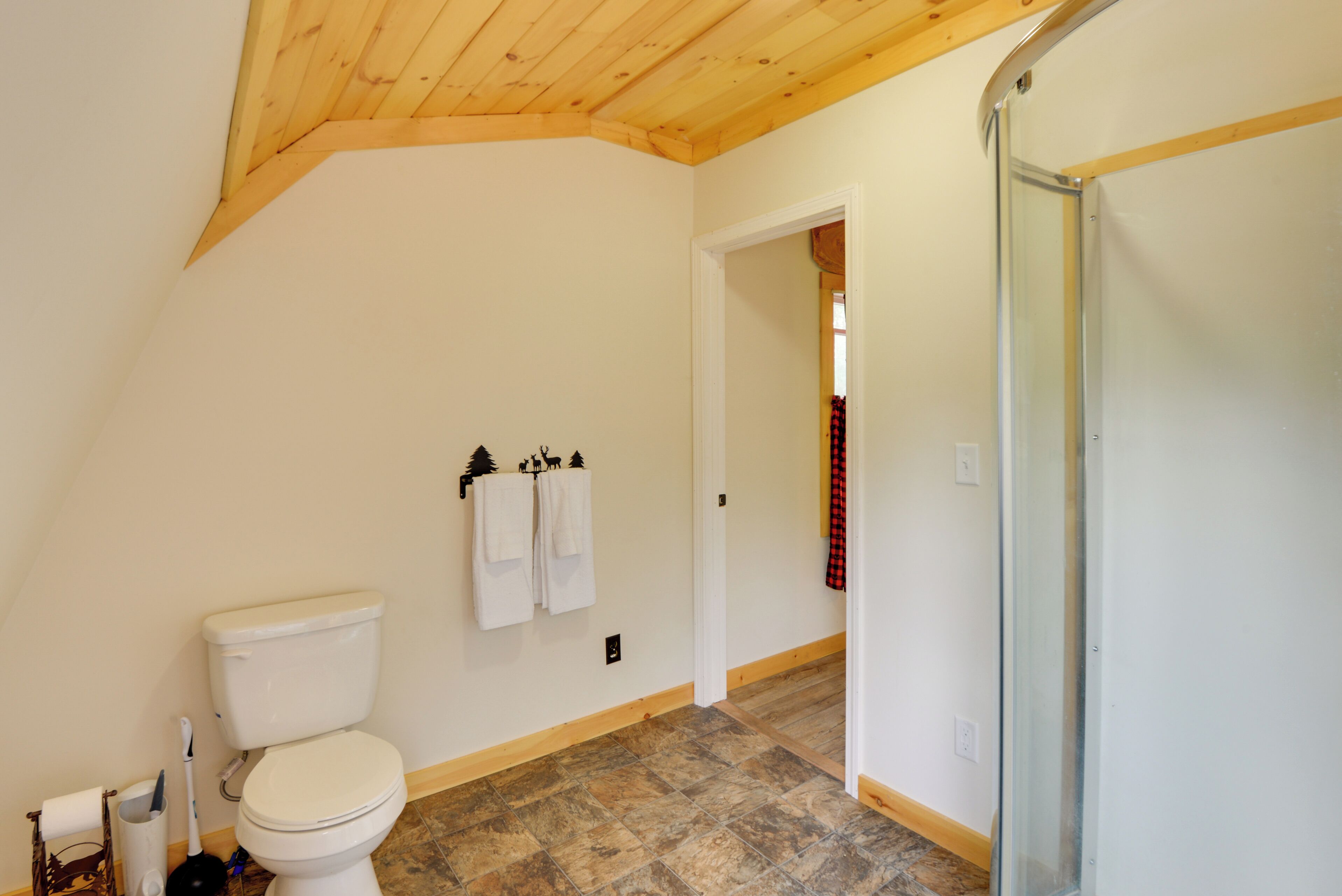 Ein Badezimmer mit Toilette, Dusche und Fliesenboden.