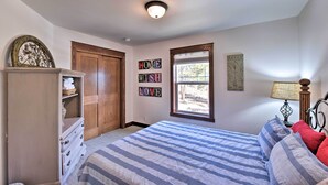 Une chambre à coucher avec un lit, une commode et une fenêtre.