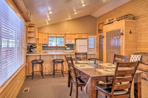 A cozy cabin-style kitchen with wooden cabinets, a central island, and a dining area with a table and chairs.