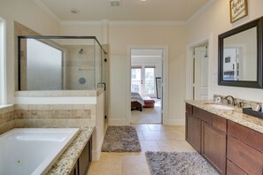 Spacious bathroom with walk-in shower, separate bathtub, and granite vanity.