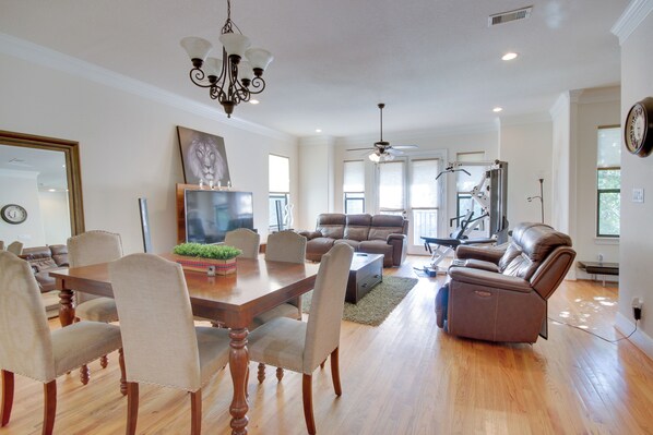 Relax in the living area with a dining table and six comfortable chairs, a large sofa, reclining chair, and exercise machine.