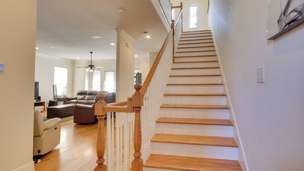 A spacious living area with a wooden staircase leading to an upper floor. - Pet-friendly Houston Home ~ 7 Mi to Downtown! (Houston)