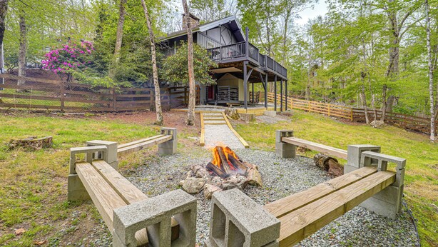 A cabin with a deck, a fire pit, and a wooden walkway leading to the entrance. - 'bear Crossing Chalet:' Beech Mountain Family Home (Banner Elk)